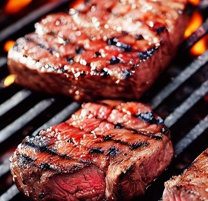 Cooked steaks on grill with Summer red wine